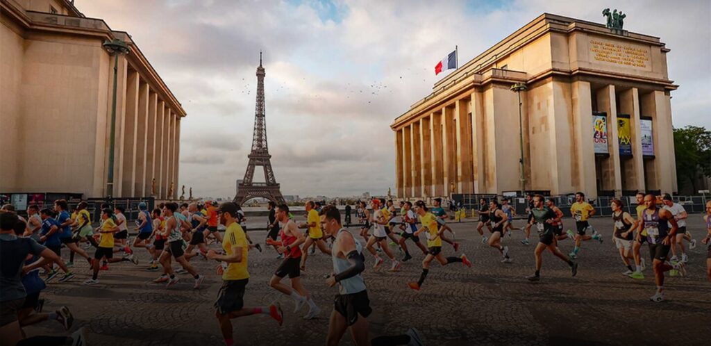 Coureurs participant à une course à pied devant la tour Eiffel, entre les bâtiments du Trocadéro à Paris.