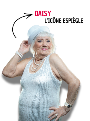 Portrait d'une femme âgée posant avec malice en robe pailletée argentée, collier de perles et chapeau blanc, une main sur la hanche, avec le texte « Daisy, l'icône espiègle ».